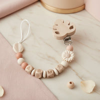 Attache tetine clip personnalisée avec clip en bois, perle marguerite crème, perle feuille et mélange de perles en silicone et bois naturel.