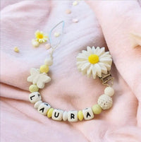 attache tétine en silicone motif marguerite de couleur blanche et jaune 