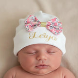 bonnet bébé fille de couleur blanc avec un noeud en liberty porter sur la tete de bébé 