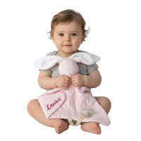 bébé présentant un doudou attache tetine lapin rose 