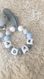 attache tétine en silicone bleu et gris avec anneau de dentition