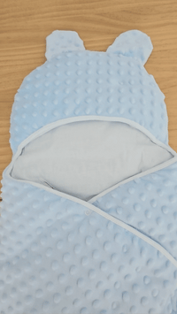 présentation d'une couverture technique d'emmaillotage bébé bleu en minky 