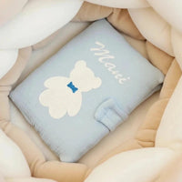 Protège carnet de santé bébé en gaze de coton bleu avec motif petit ours blanc et personnalisation en flocage.